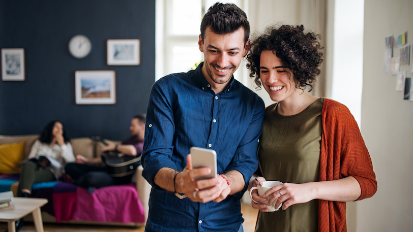 Young man and woman looking at mobile phone