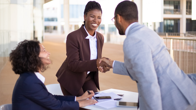 business colleagues shaking hands and smiling